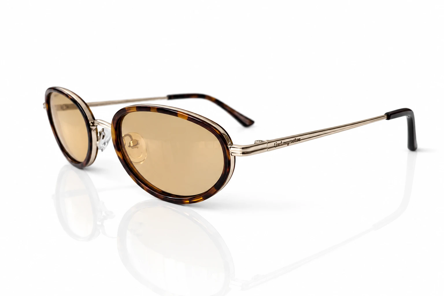 lunettes-de-soleil-ecaille-lenses-ambrées Lunettes de soleil à monture écaille ronde et verres ambrés, avec branches fines métalliques et logo discret.