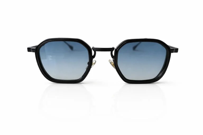 Lunettes de soleil à monture noire hexagonale, avec des verres bleus dégradés.