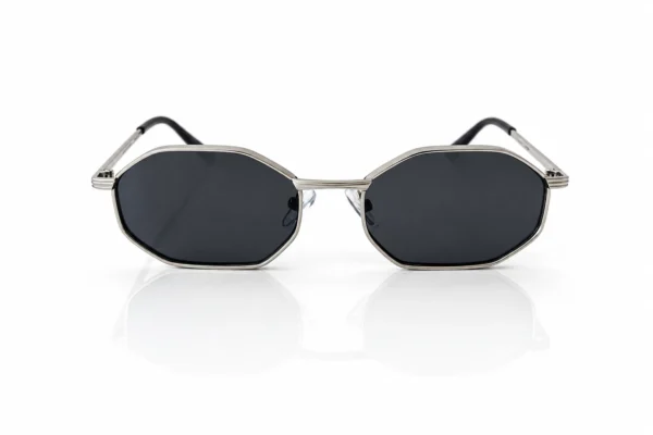 Paire de lunettes de soleil octogonales à monture argentée et verres noirs, sur fond blanc avec reflet.