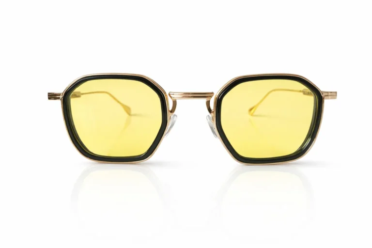 Gros plan sur des lunettes de soleil avec monture dorée et noire, et verres jaunes vifs.
