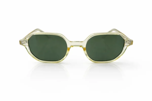 Gros plan sur une paire de lunettes de soleil vintage à monture transparente et verres verts, sur fond blanc.