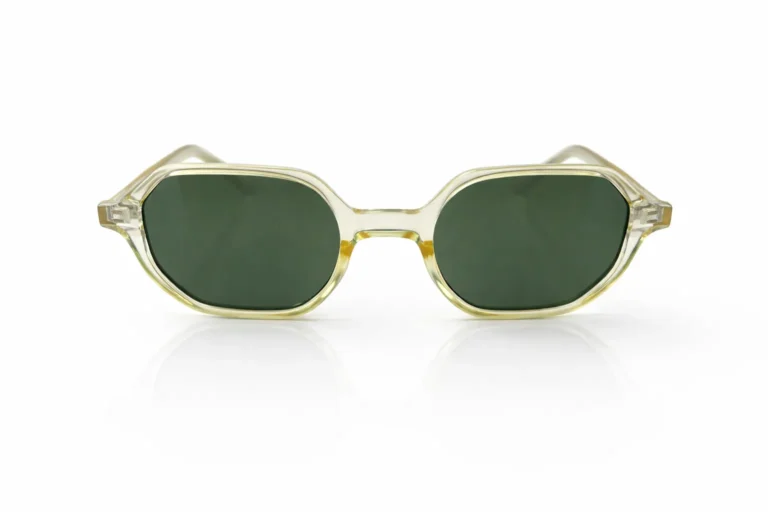 Gros plan sur une paire de lunettes de soleil vintage à monture transparente et verres verts, sur fond blanc.